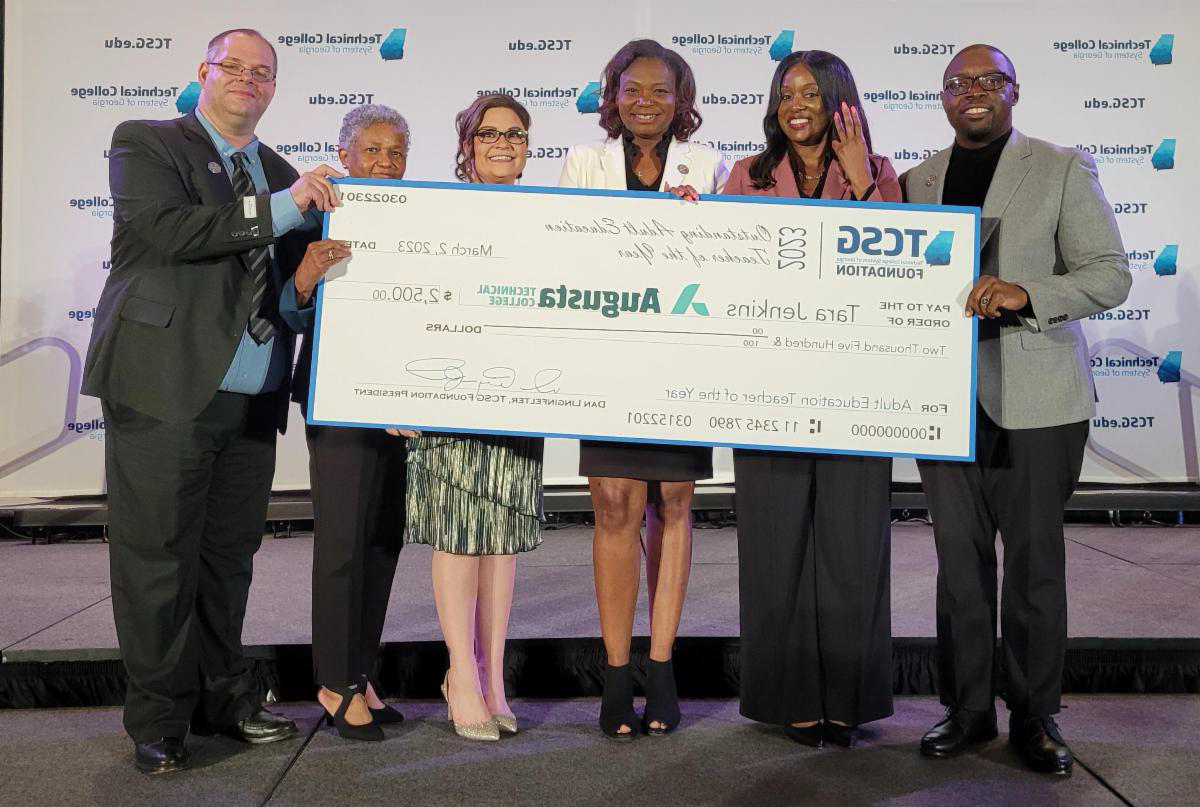 Dr. 旋转, 买世界杯app推荐院长, stands with the 2022 and 2023 成人教育 Teacher of the Year winners as well as the 2022 EAGLE winner and Dean Moseley while holding the check from TCSG.